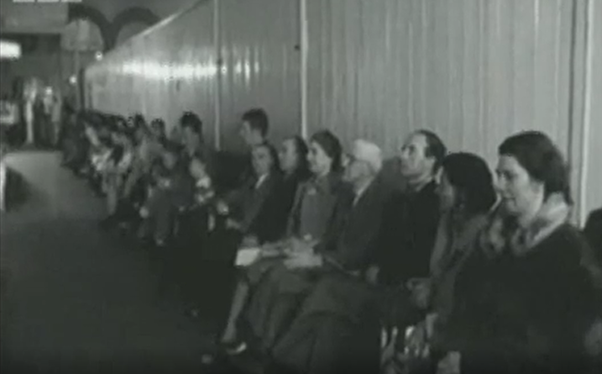 Line of people queuing in a hospital from a BBC documentary about the NHS 1968.