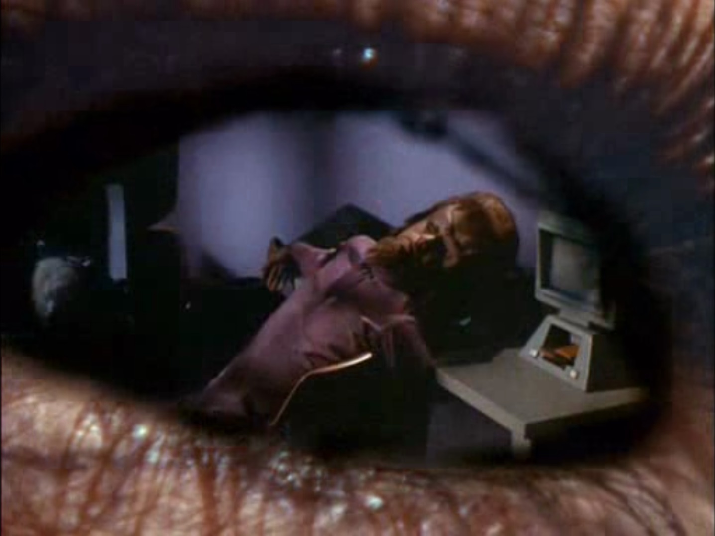 Image of a collapsed Tellarite in his chair superimposed on a close-up of Mira's eye