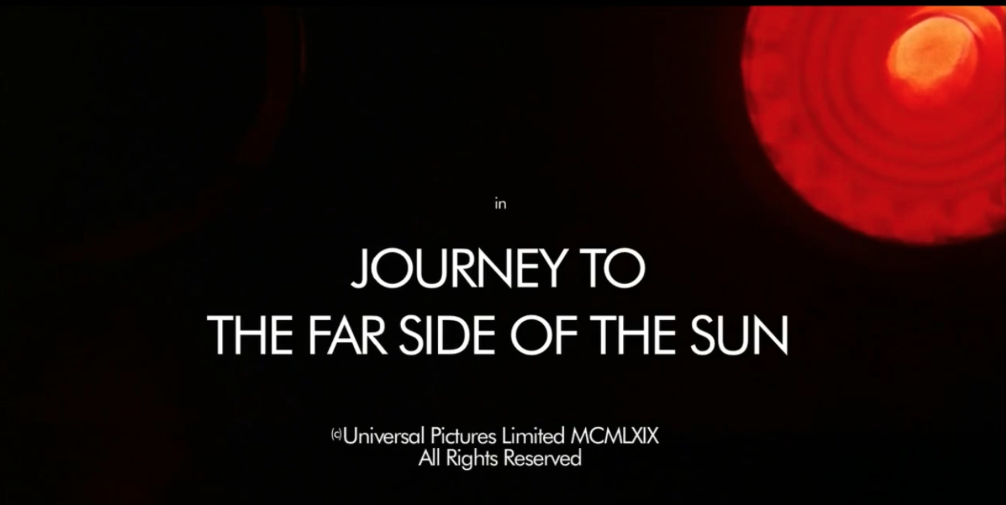 Title screen for the movie Journey to the Far Side of the Sun. The title is in white at the center of the the image which is black except for a huge red spot in the upper right corner.