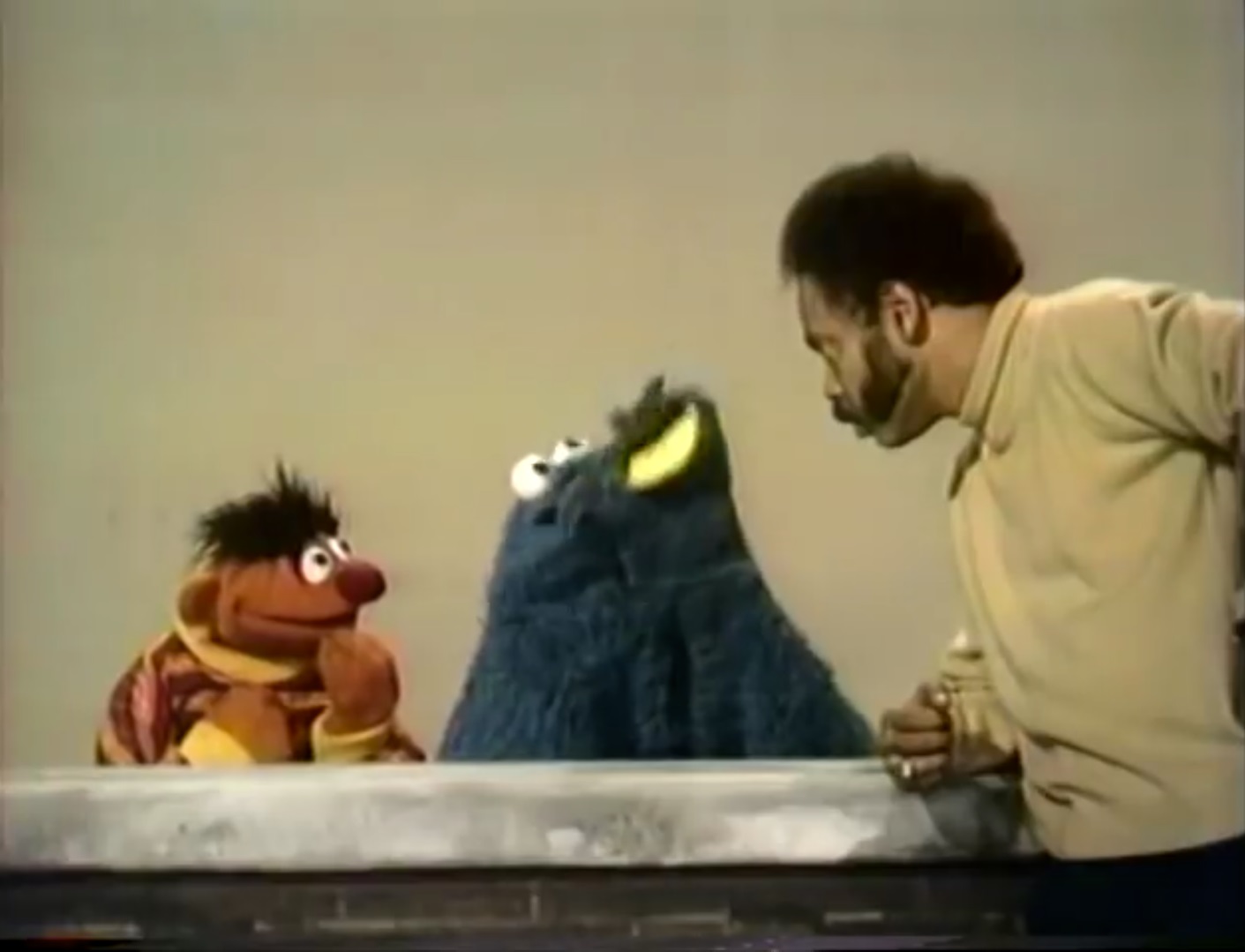 still photo of Gordon and Ernie of looking in disbelief at the blue furry puppet's tootling