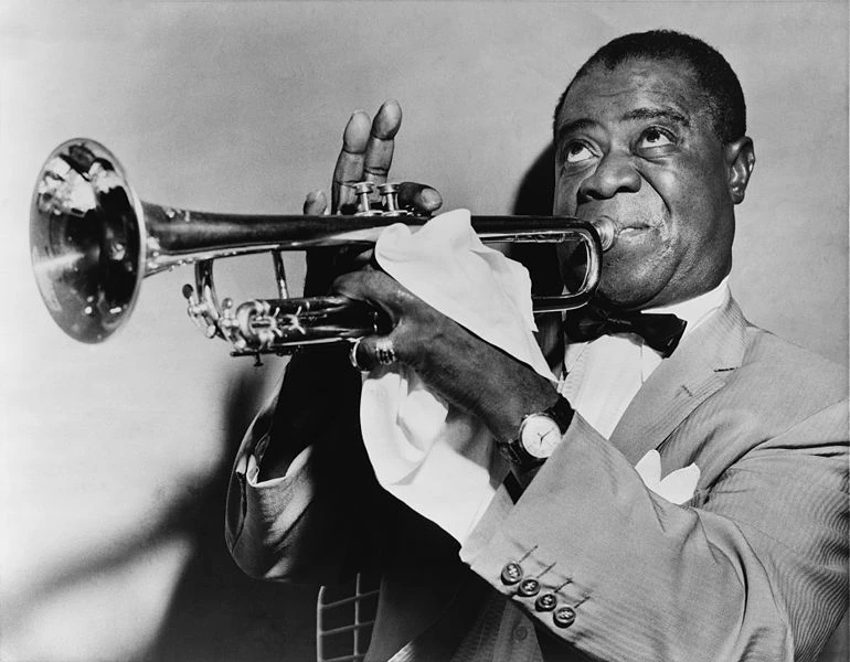 A photograph of Louis Armstrong playing the trumpet.
