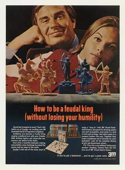 Colour photograph of a magazine advertisement, purporting to show 'How to be a feudal king (without losing your humility)'.  A white man and woman are posed behind a game board, with white and black pieces arranged in a dramatic vignette.