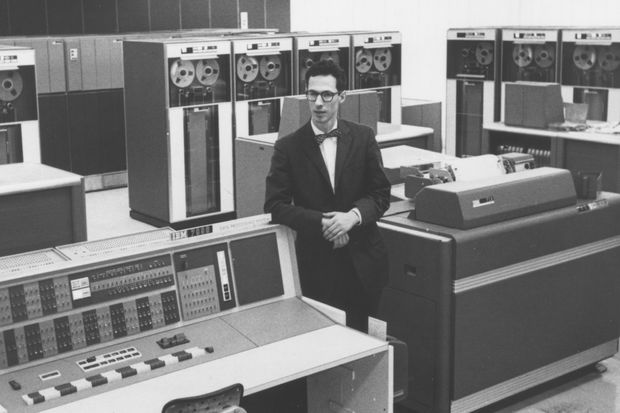 Fernando Corbato stands amidst an IBM 7090 computer system.