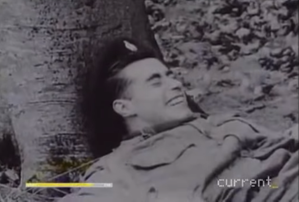 Picture of a soldier lying down near a tree and laughing