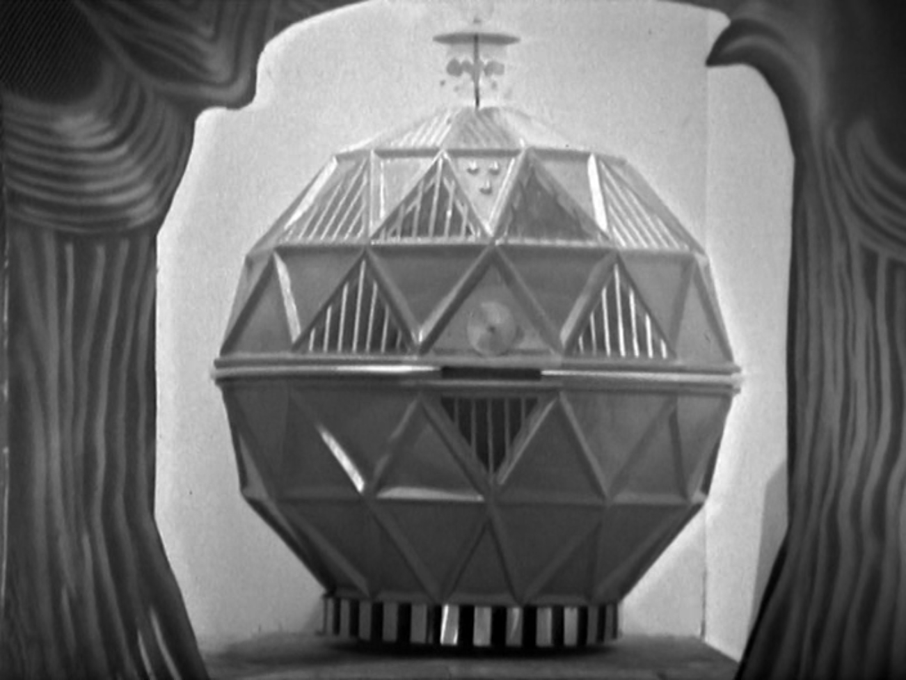 Image description: A machine shaped like a geodesic sphere sits in a lit doorway.