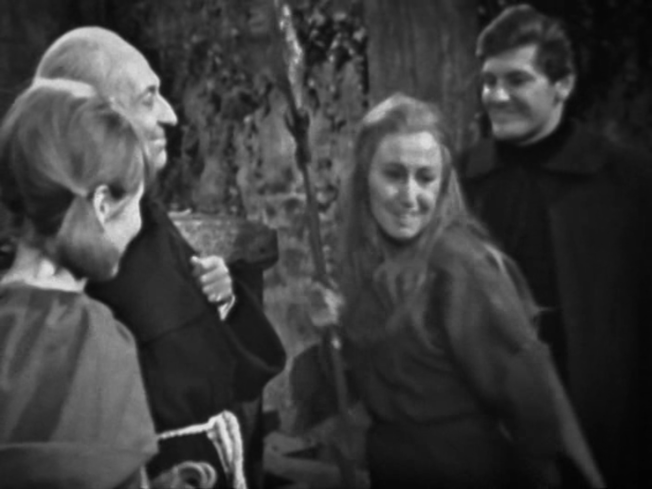 Image description: Vicki, the Doctor, and Steven stand with Edith. Edith is holding a spear.