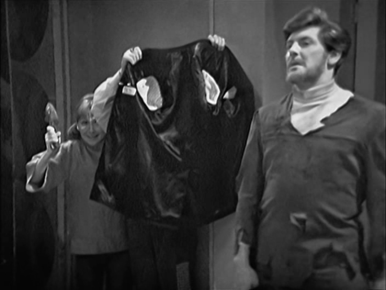 Img description: Steven stands in the foreground. In the background, the Doctor uses his coat as a shield and Vicki wields a shoe.