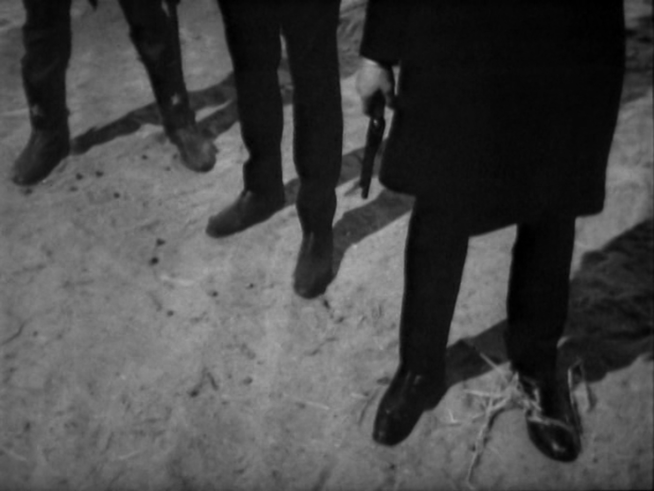 Image: The Earps and Holliday stand side by side. Only their legs are visible.