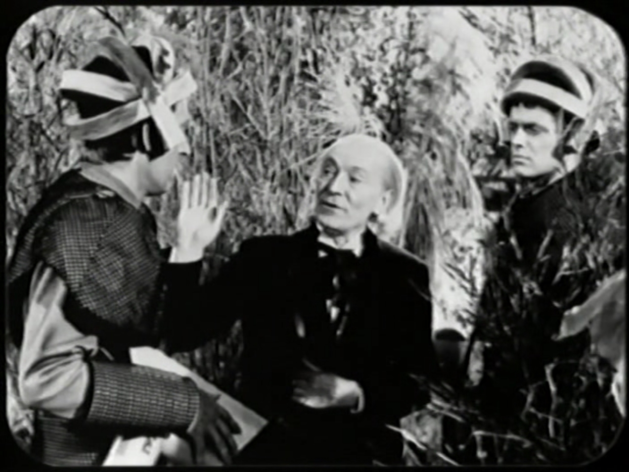 The Doctor, centre, with Exorse and Edal. Exorse and Edal are wearing strange helmets. 