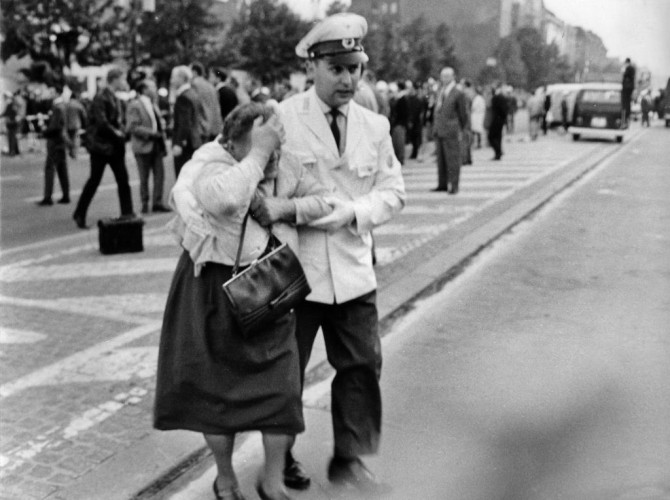 West Berlin traffic cop escorts elderly lady to safety