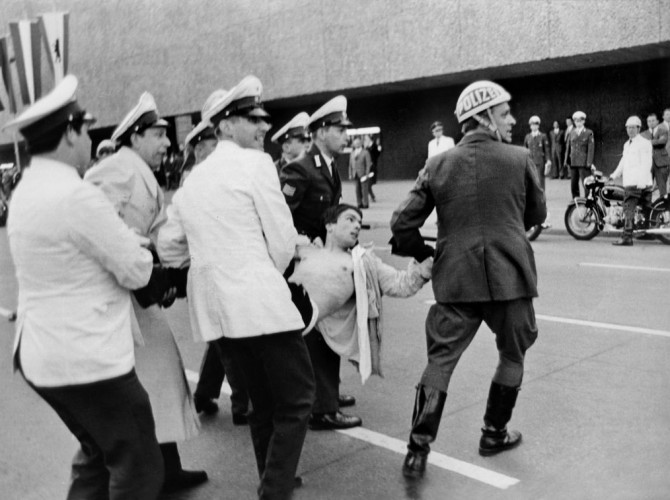 Police officers carry off a student protester