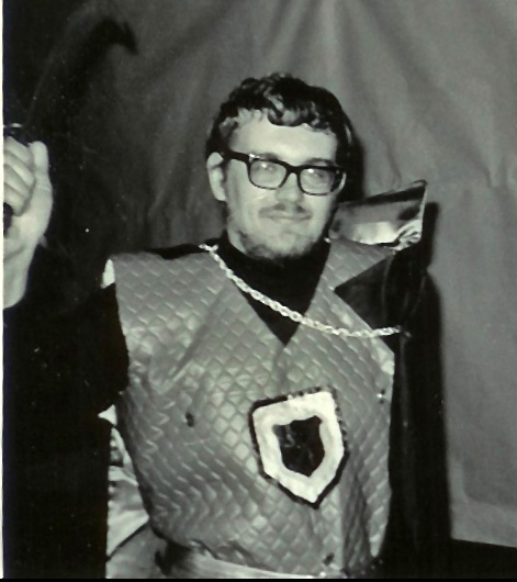 A photo of a young man in glasses dressed rather inexpertly as a knight