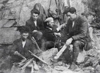 4 IRA members in 1922 in front of a tent around a camp fire.