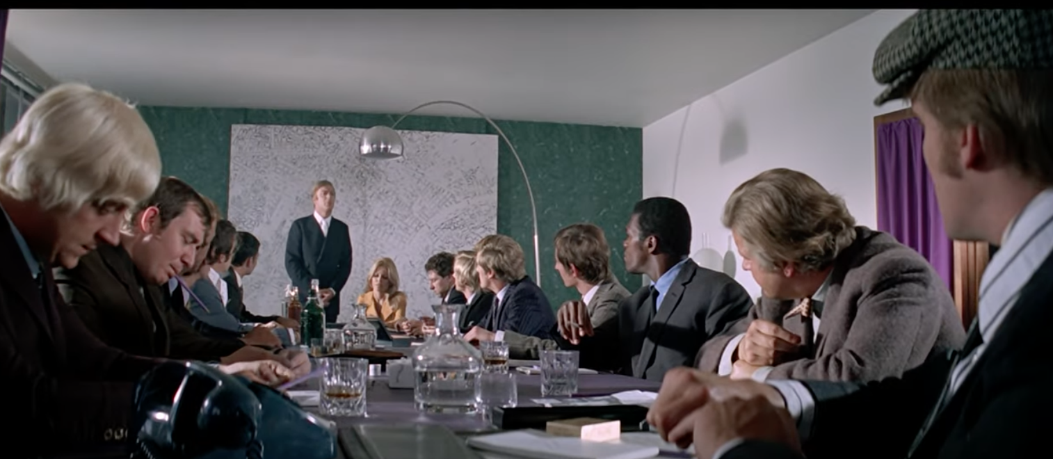 Coker (Michael Caine) briefing his diverse band of criminals.