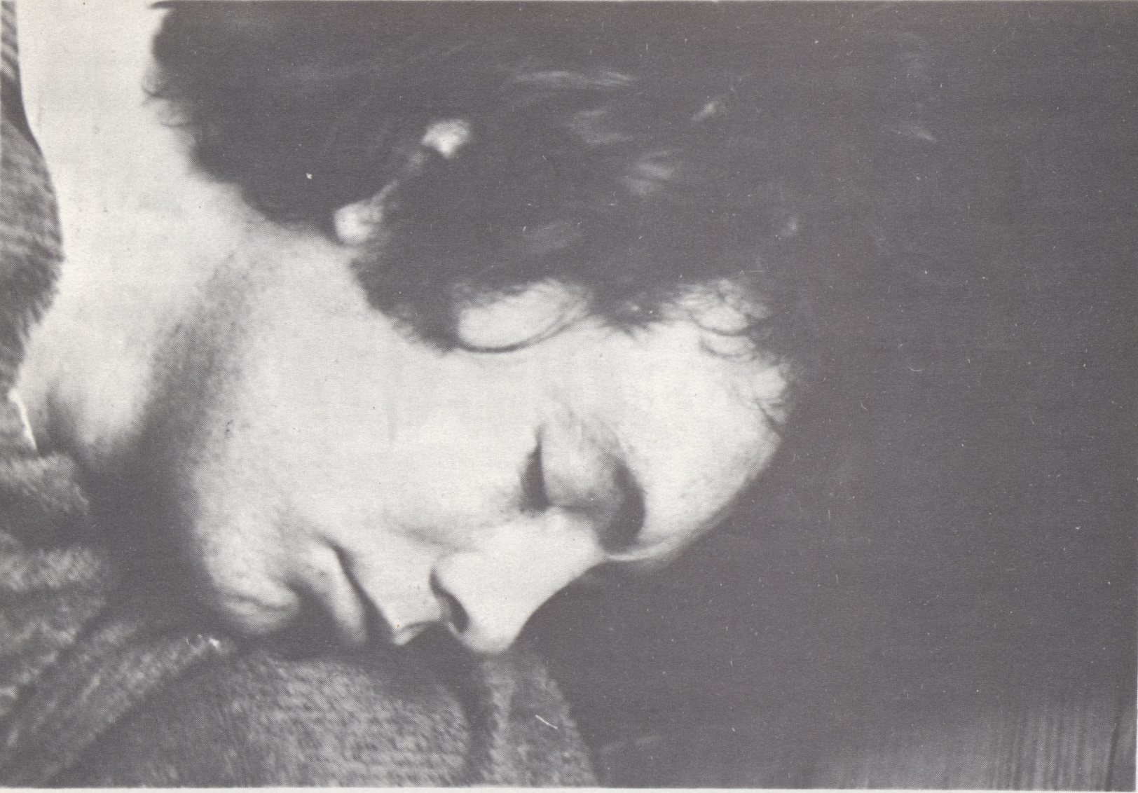 BW photograph of a man with closed eyes. He seems to be sleeping.