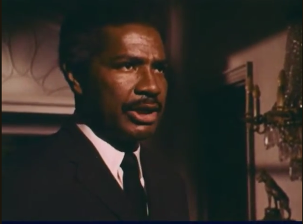 Still frame from the TV series Night Gallery. It shows actor Ossie Davis playing the character Portifoy. He's a Black man with a moustache, wearing a suit and tie.