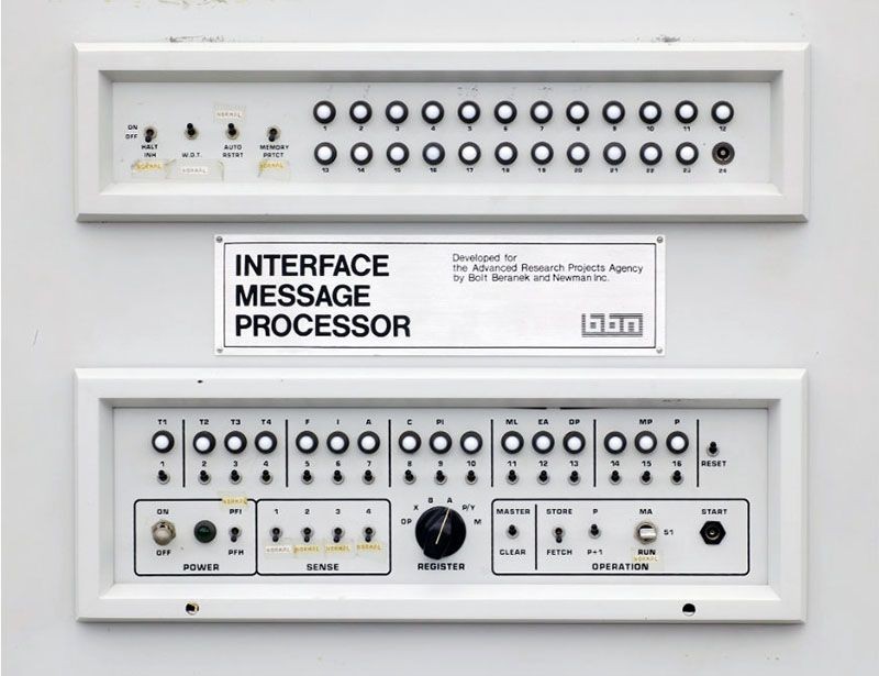 Photograph of a switchboard with dozens of buttons and dials. The board is labeled: Interface Message Processor.