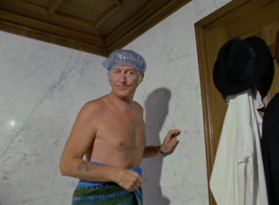 The Doctor fresh out of the shower with a towel around his waist and a shower cap on. There's a serpent tattoo vaguely resembling a question mark on his right forearm. 