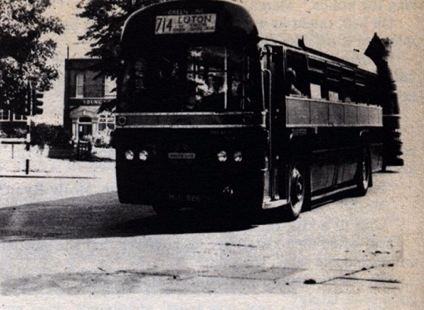 Black and white photograph of a double decker bus in an urban street