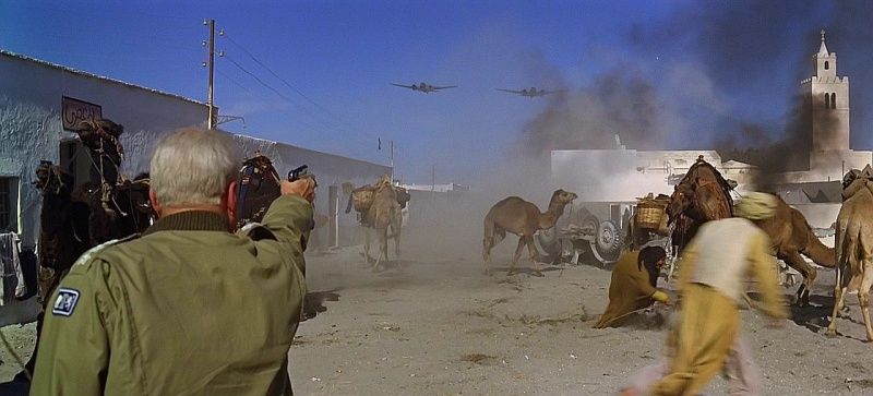 A wide, chaotic battle scene in a desert city, with Patton firing into it