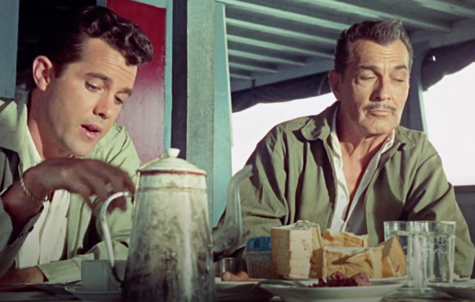 Color image of the clean-shaven Hero and the elderly, mustachioed scientist sharing coffee and sandwiches. The Hero is sitting on the left, and the scientist on the right.