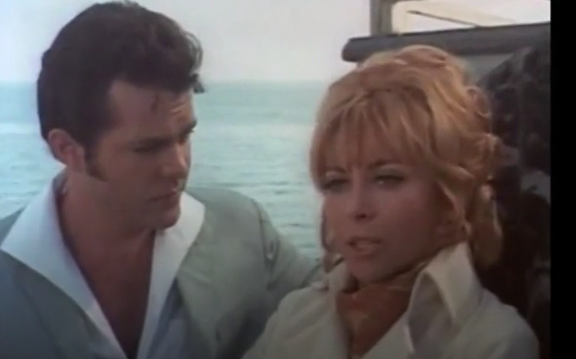 A color image of the two main characters. The Girl, who has reddish blonde hair, is on the right. The Hero is on the left, with a fabulous greaser hairdo and a shirt unbuttoned to his sternum.
