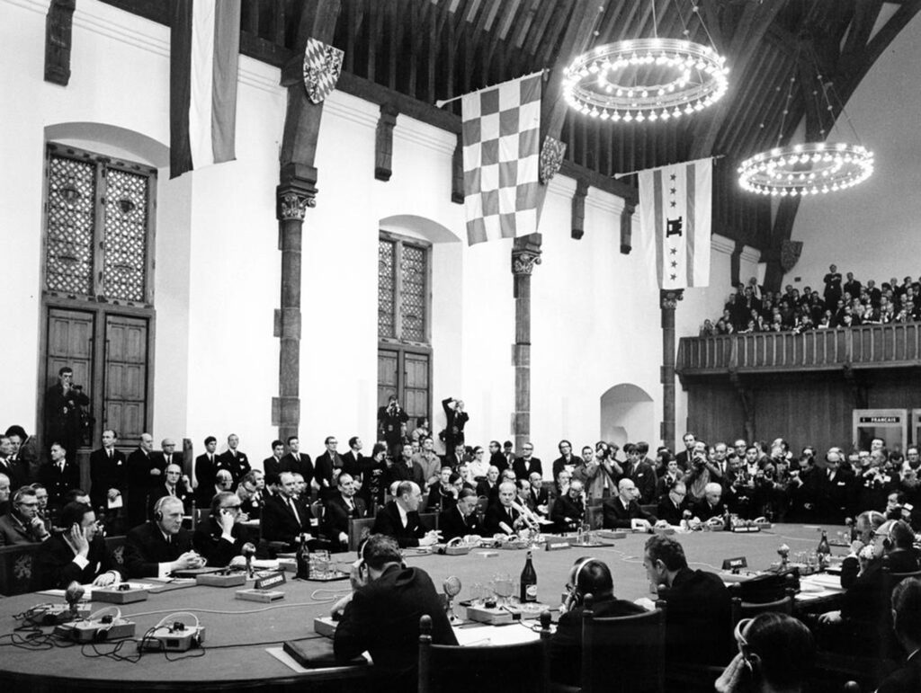 Black and White Photo of the December Hague Summit 1969 showing people around a long table in The Hall of Knights in the Hague
