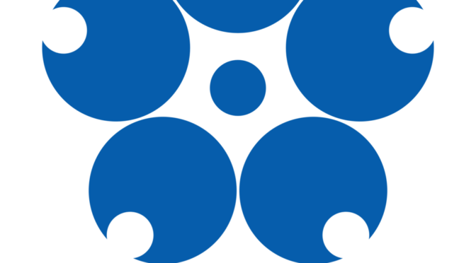 Official logo of Expo 70. A small filled circle in blue is surrounded by five equally-spaced larger solid blue circles, each with a small bite taken out of it. The design represents a Japanese cherry blossom
